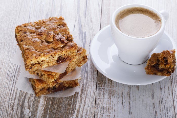 Coffee cup and pastries on wood planks
