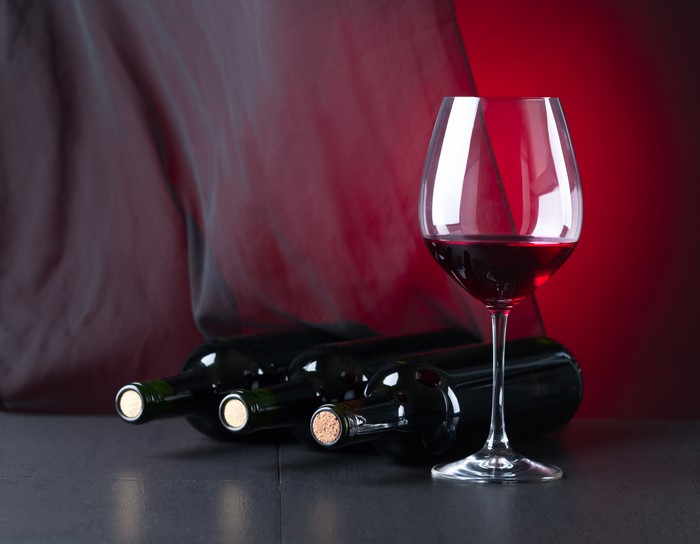 Wine bottles and glass with red background