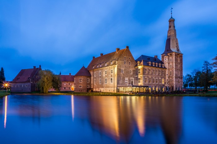 Castle Raesfeld reflected in a pond at dusk
