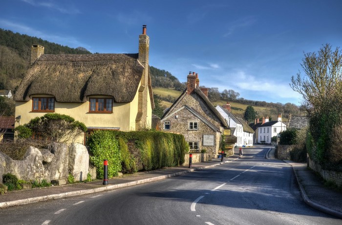 Village street with thatched and stone houses in Axmouth, East Devon, UK