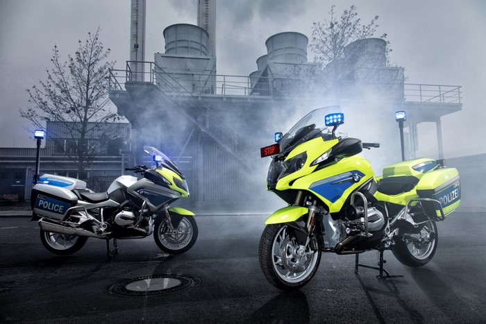 Two BMW Police Motorcycles in front of Industrial Building