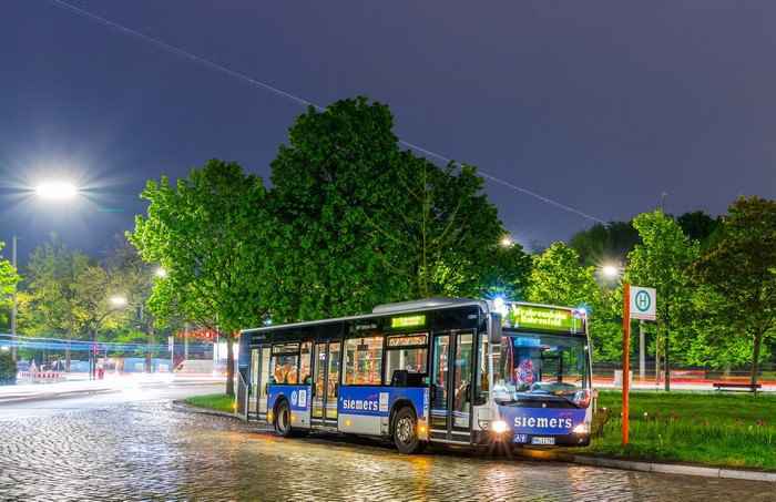Siemens bus at a bus stop at night