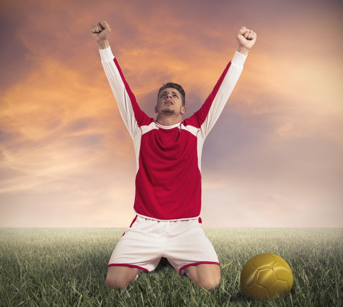 Soccer Player Kneeling with Arms Raised