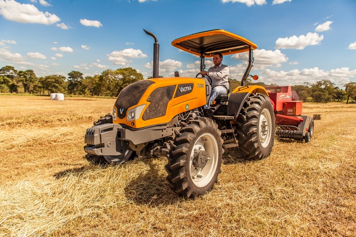 Valtra A650 B tractor baling hay in a field