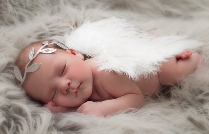 Newborn baby with angel wings and laurel wreath