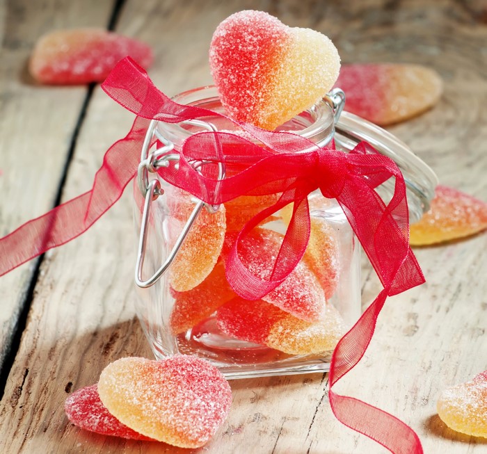 Heart-shaped marmalade candies in a jar with a red ribbon