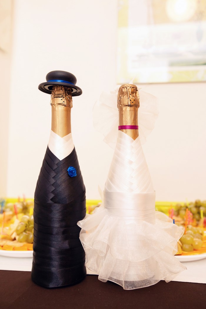 Champagne bottles decorated as bride and groom