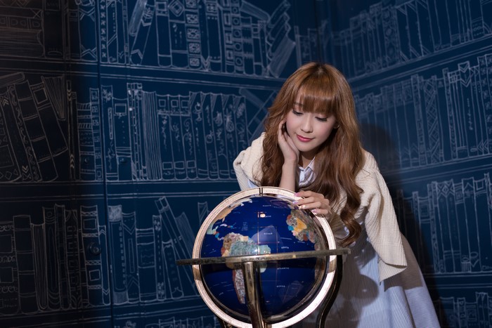Asian woman with brown hair and a globe