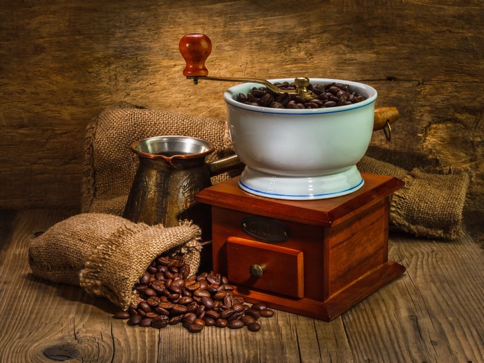 Coffee beans, grinder, and cezve on wooden table