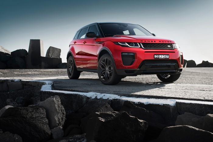 Red Land Rover Evoque on rocky shore