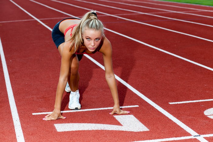 Blonde girl at the start line on a running track