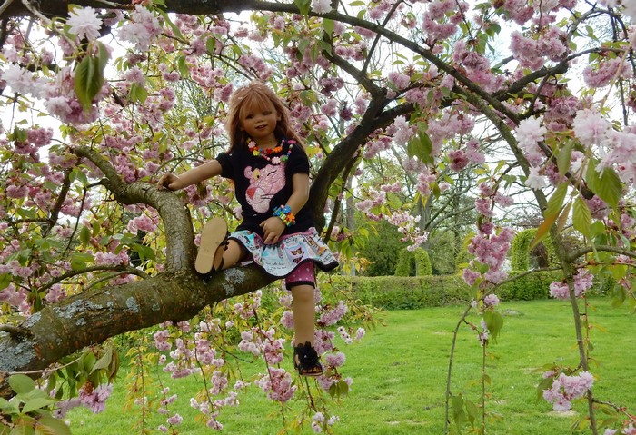 Doll sitting on a flowering tree branch in Grugapark Essen