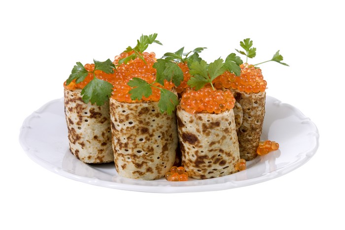 Pancakes with red caviar and parsley on a plate
