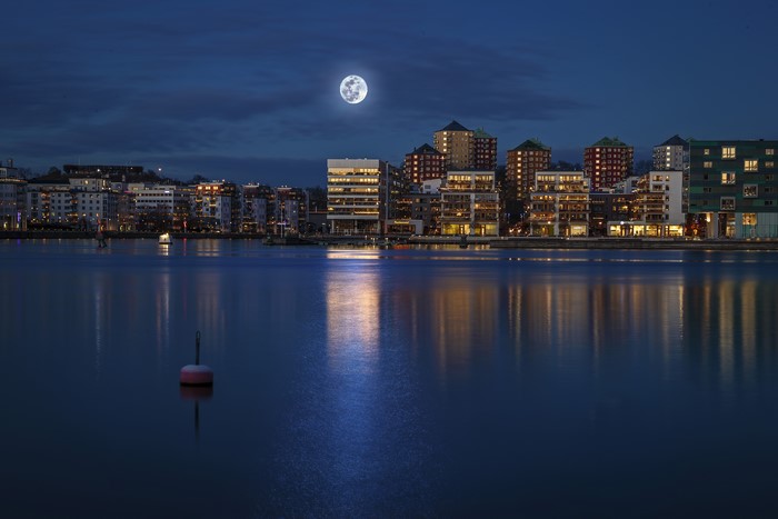 Stockholm at night with full moon over river