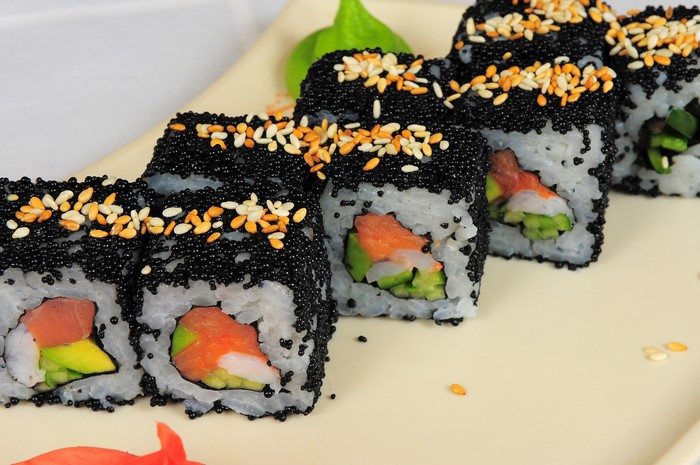 Sushi rolls with black caviar and sesame seeds