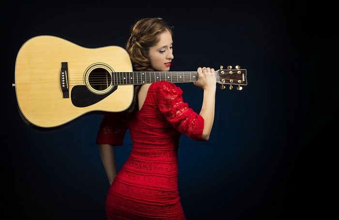 Woman in red dress holding a guitar