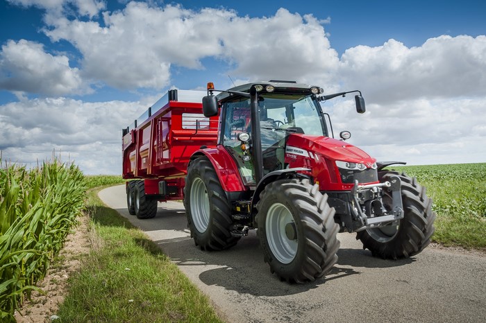 Massey Ferguson 5609 tractor pulling a red trailer