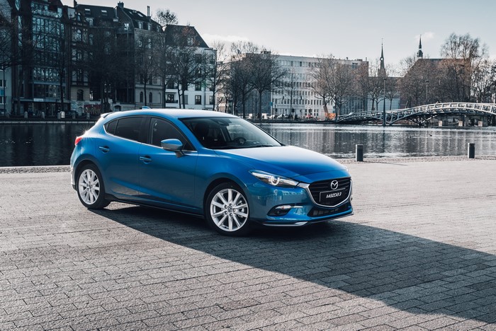 Blue Mazda 3 Hatchback parked by a canal