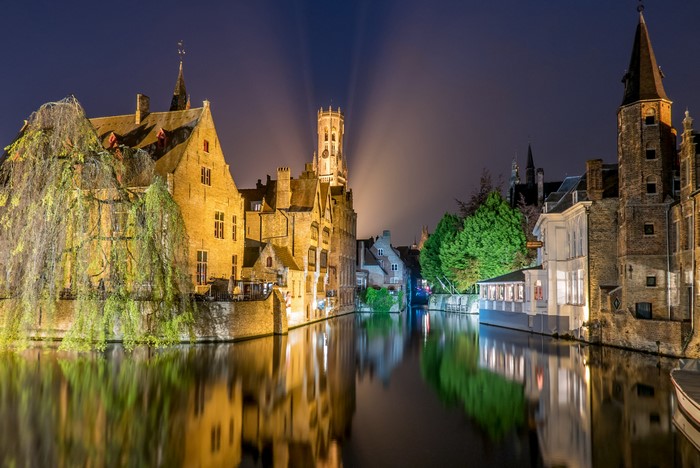 Bruges canal at night with illuminated buildings and reflections