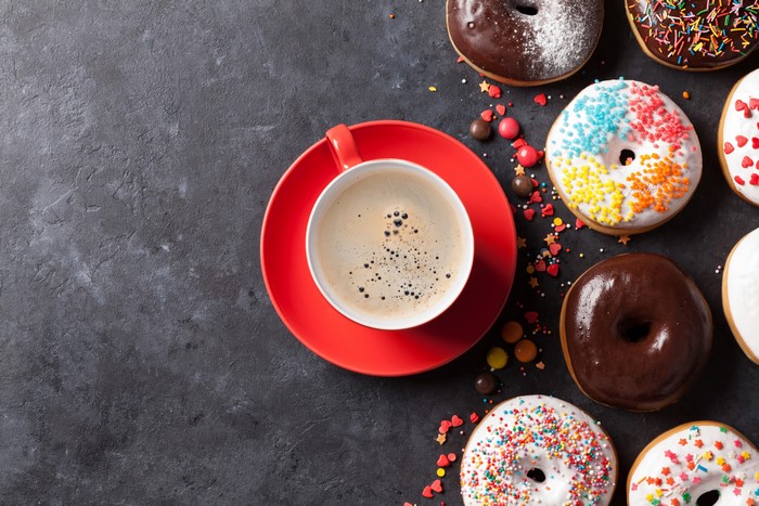 Coffee cup and donuts on gray background