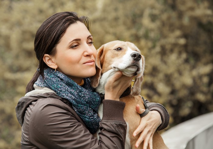 Woman holding a beagle dog outdoors