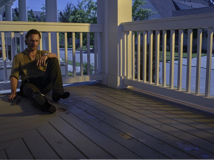 Rick Grimes from The Walking Dead sitting on a porch