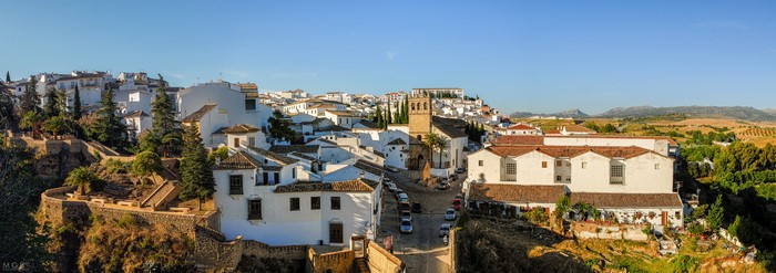 Panoramic view of Ronda, Spain with white houses and a church tower