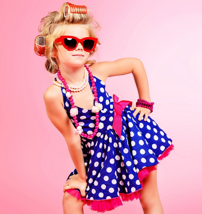 Girl in polka dot dress with sunglasses and hair rollers
