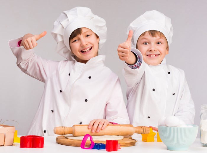 Two young chefs giving thumbs up