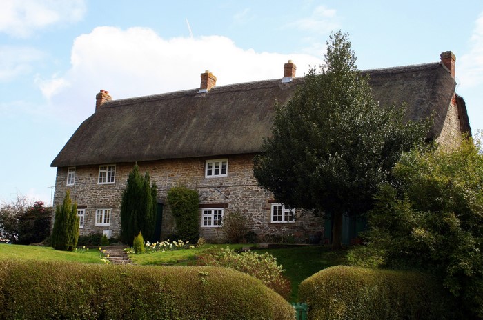 Thatched stone cottage in Hodson village, Wiltshire, England