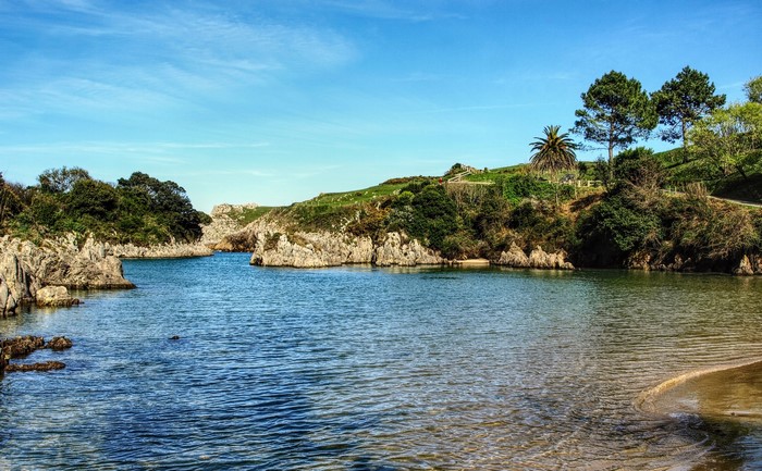 Coastal bay with rocky outcrops and green hills in Spain