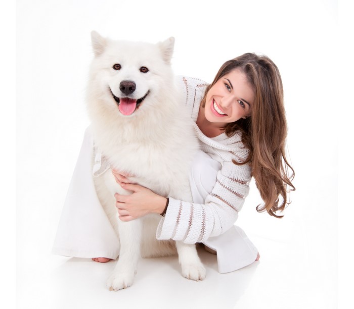 Woman hugging a white Samoyed dog