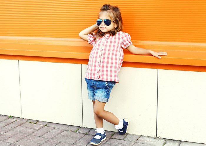 Little girl in sunglasses and shorts