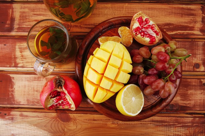Fruit platter with tea on wooden planks