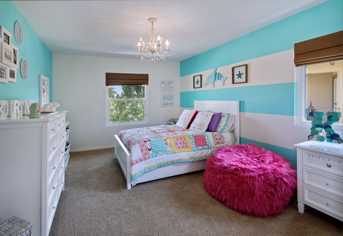 Bedroom with striped walls and a chandelier