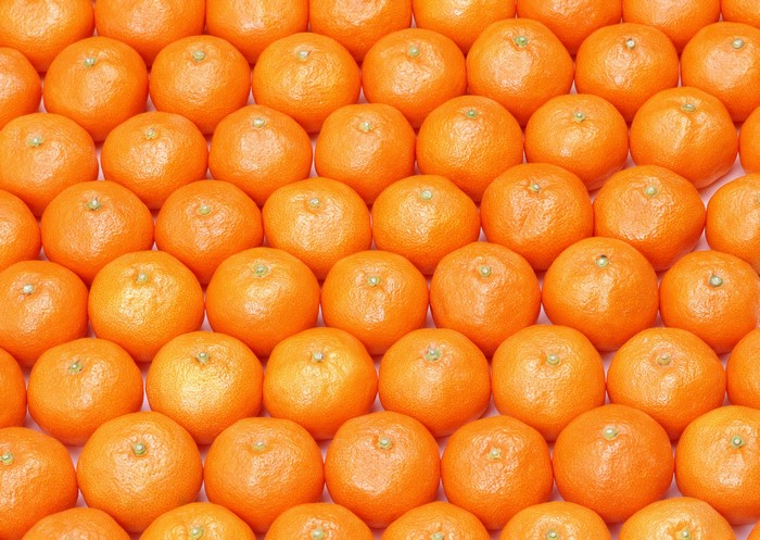 Many tangerines arranged in rows