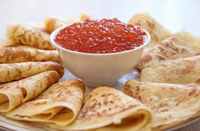 Pancakes with red caviar in a bowl