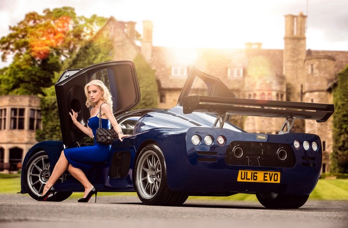 Blonde woman in blue dress with blue Ultima Evolution Coupe