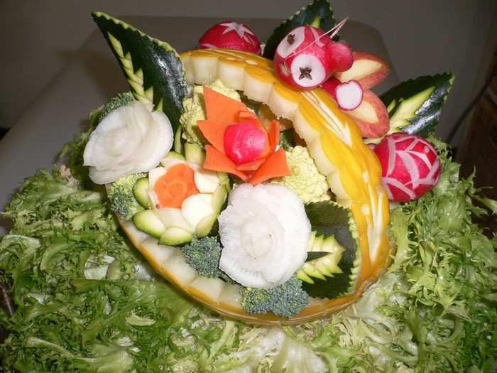 Carved vegetables and fruits arranged in a basket design