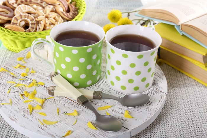 Two cups of tea with cookies and books