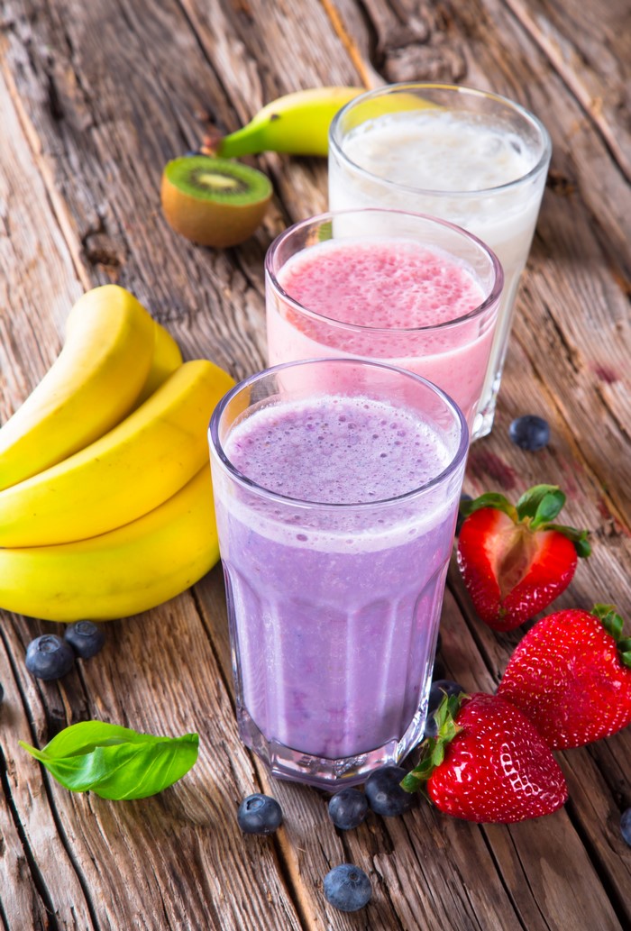 Three fruit smoothies with bananas, strawberries, and blueberries