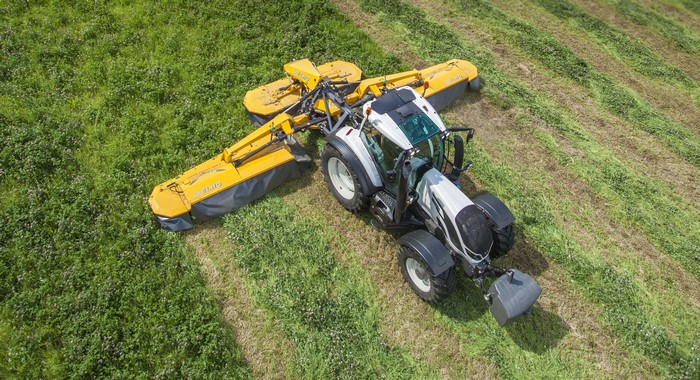 4K Valtra T Series tractor with mowers in a field