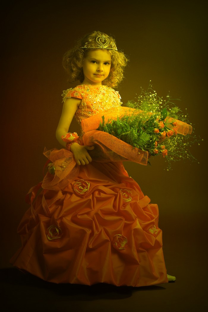 Girl in a princess dress with a crown and bouquet