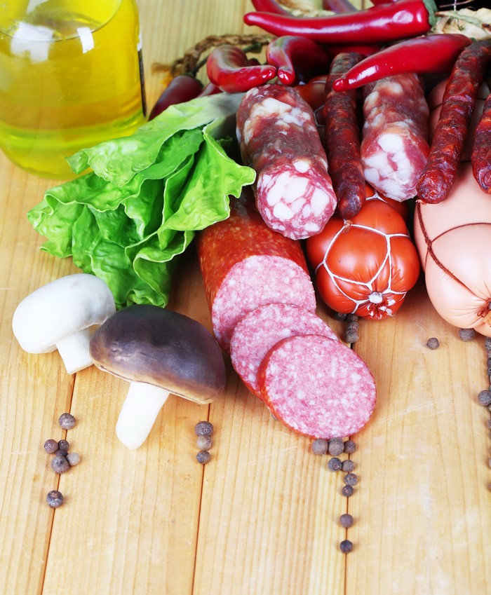 Sausages, mushrooms, and chili peppers on wood planks