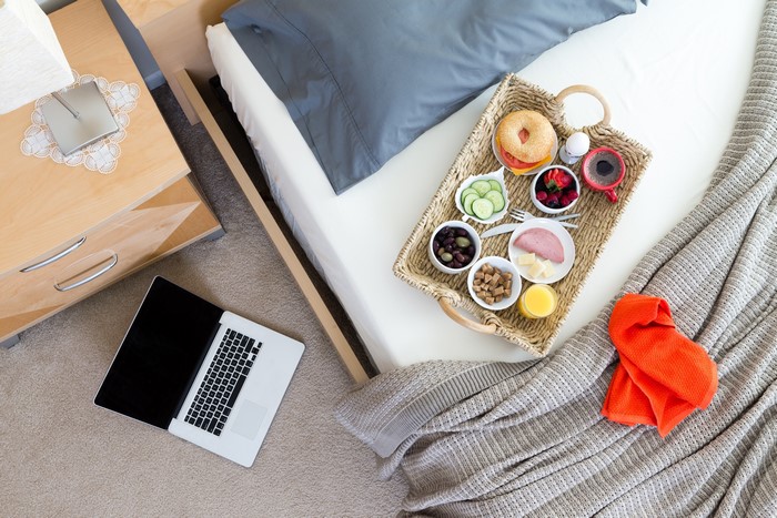 Bed with breakfast tray and laptop