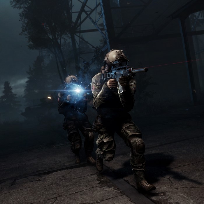 Soldiers in tactical gear firing assault rifles at night