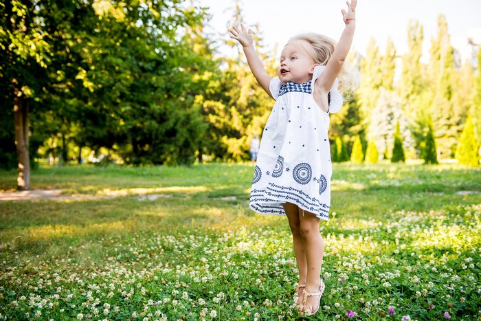 Little girl in a dress jumping in a park