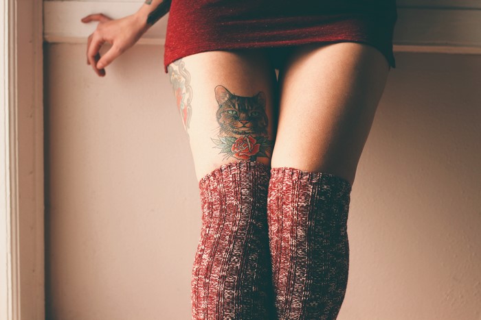 Woman with cat tattoo and knee-high socks