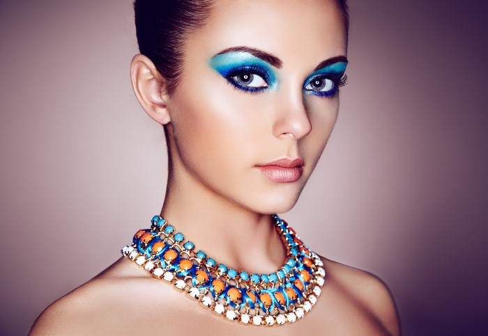 Woman with blue eye makeup and colorful necklace