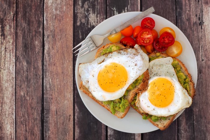 Avocado toast with fried eggs and cherry tomatoes